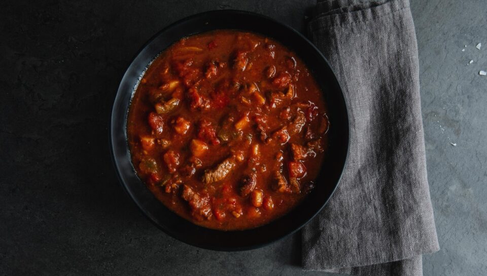meat-vegetable-stew-served-dark-bowl-grey-background_1220-6638